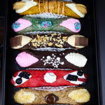 Whether you're treating yourself to a moment of indulgence or sharing with loved ones, our SetBox of 6 Large Gourmet Cannoli is tasting the dolce vita! Handcrafted with care and made with the finest ingredients, these cannoli are a true testament to the artistry of Italian pastry-making with a twist!  Featured in our SetBox of 6 Small Gourmet Cannoli are (top to bottom):&nbsp; The Maple Oreo, Nerdilicious, The Feastables, The Neapolitan, The Pavlova, and The Cappuccino.&nbsp; &nbsp;Enjoy!!