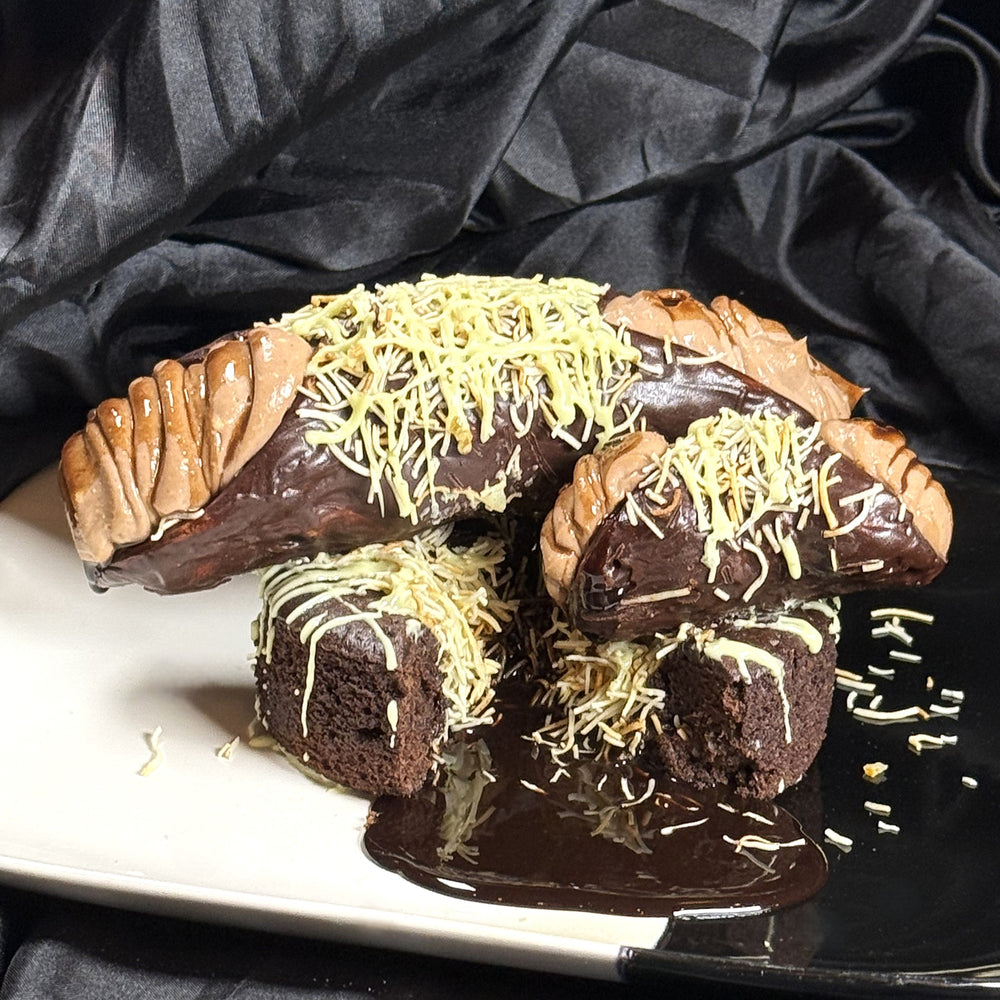 Our Dubai Chocolate Lava Cannoli is pure decadence wrapped in crisp perfection. Each cannoli features a chocolate-coated pastry shell, filled with smooth chocolate ricotta cream for a lush, balanced sweetness. The ends overflow with molten chocolate syrup, creating that irresistible lava effect with every bite. Topped with a nest of golden kataifi and a drizzle of pistachio cream, it’s a showstopping fusion of Italian craft and Middle Eastern flair—made for those who love their desserts dramatic, and rich.