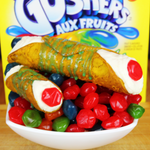 Introducing our delectable Candy Gusher Cannoli – a delightful fusion of traditional Italian pastry and the explosive burst of fruity candy goodness! This unique and playful treat is a feast for your senses, promising an unforgettable experience for candy and cannoli enthusiasts alike.
