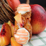 Our Smooth Peach Cannoli is a celebration of the ripest, most succulent nectarines you can imagine. Inside the crispy, crunchy pastry shell, you'll discover a luscious filling made from our housemade nectarine emulsion blended with our smooth and creamy ricotta.  The ends are decorated with nectarine icing and a slice is perched atop.  This vibrant fruity cannoli bursts with natural sweetness, tangy undertones, and a refreshing juiciness that's perfect for warm autumn days.