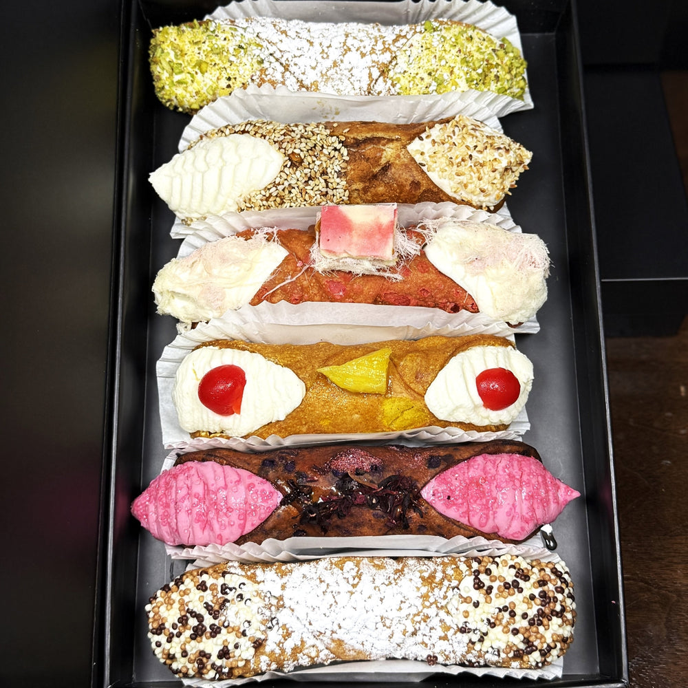  Included in the SetBox of 6 Large Cannoli are:


Top to bottom:&nbsp; Traditional Pistachio, The Honeyed Sesame, The Pink Angel Hair Chocolate, The Upside-Down Pineapple, The Hibiscus, and Traditional Chocolate.


Whether as a special treat for yourself or a delightful gift, this SetBox offers an authentic taste of Italy that will satisfy the Foodie in you!