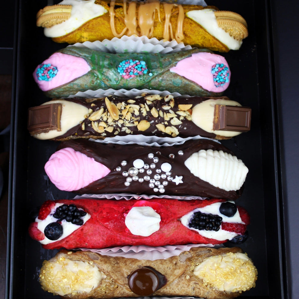 Whether you're treating yourself to a moment of indulgence or sharing with loved ones, our SetBox of 6 Large Gourmet Cannoli is tasting the dolce vita! Handcrafted with care and made with the finest ingredients, these cannoli are a true testament to the artistry of Italian pastry-making with a twist!  Featured in our SetBox of 6 Small Gourmet Cannoli are (top to bottom):  The Maple Oreo, Nerdilicious, The Feastables, The Neapolitan, The Pavlova, and The Cappuccino.   Enjoy!!