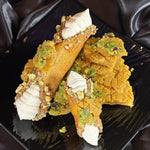 Our Sohan Cannoli combines the rich, buttery crunch of Persian Sohan with the creamy decadence of a classic Italian cannoli. Each crisp, saffron-infused pastry shell is handcrafted with pistachios on the ends capturing the essence of Iran’s beloved Sohan brittle.

Inside, a luscious filling of rosewater-kissed ricotta&nbsp;adds a creamy contrast, blending two cultures into one irresistible treat. Finished with a chunk of artisanal Sohan brittle.