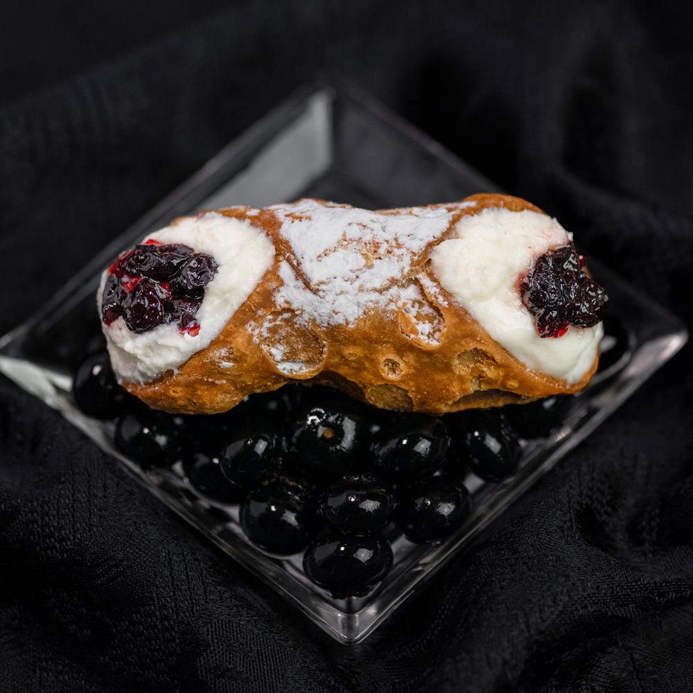 Cannoli Crunch presents our Signature Black Currant Jelly cannoli that will make your mouth water! Our smooth, creamy ricotta is combined with this sweet berry piped into our crispy crunchy shell.  Icing sugar is powdered on top to keep it elegantly traditional.  Enjoy!